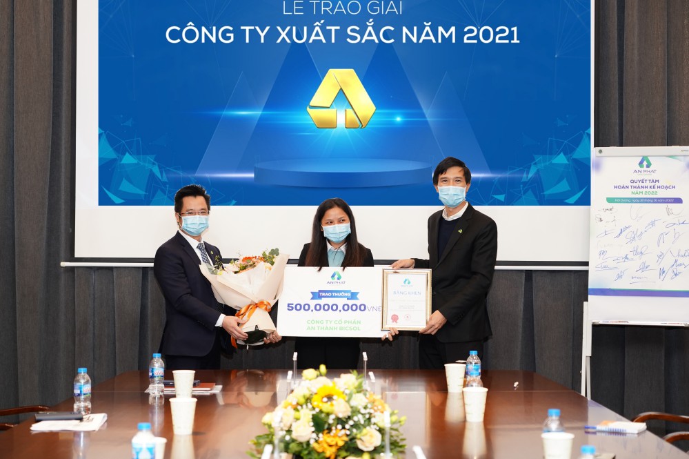 Ông Nguyễn Lê Trung – Phó Chủ tịch Tập đoàn (phải) và ông Đinh Xuân Cường – Phó Chủ tịch, TGĐ Tập đoàn (trái) tặng hoa chúc mừng An Thành Bicsol – đơn vị xuất sắc nhất trong hoạt động sản xuất kinh doanh năm 2021.